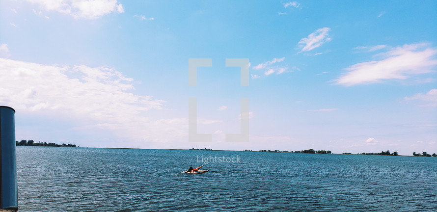 woman floating on a tube on a lake 