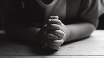 Small child praying - black and white