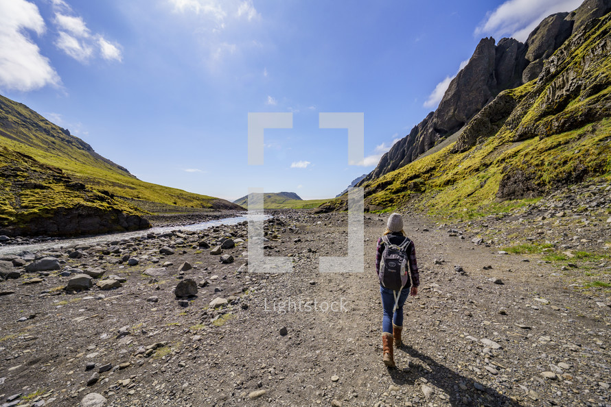 a woman walking beside of a river in Iceland 