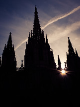 Rays of sunlight break through a silhouette of a gothic church cathedral