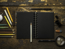 black paper notebook and colored pencils 