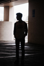 silhouette of a man in a parking garage 