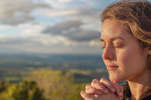 Christian worship and praise. A young woman is praying and worshiping in the evening.