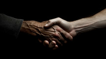 Close-up shot of a handshake with black background.