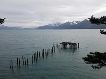 old wood posts from a washed away pier on a mountain lake 