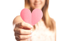 woman holding a pink paper heart