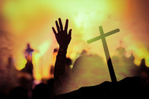 silhouettes of raised hands and cross