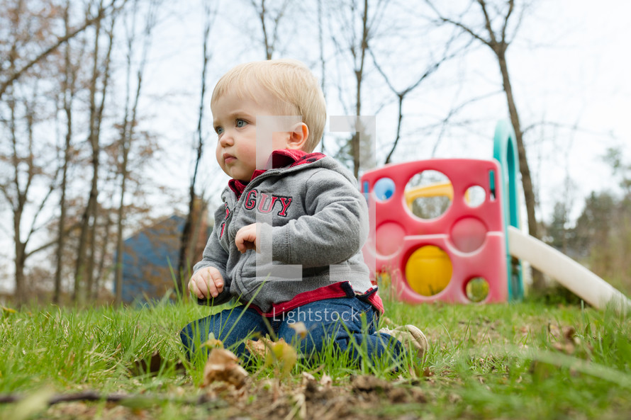 toddler boy sitting in grass