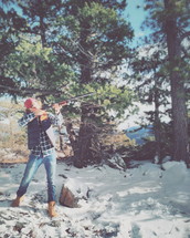 man with a shotgun in a snowy forest 