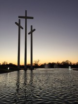 crosses in front of a pond at dusk 
