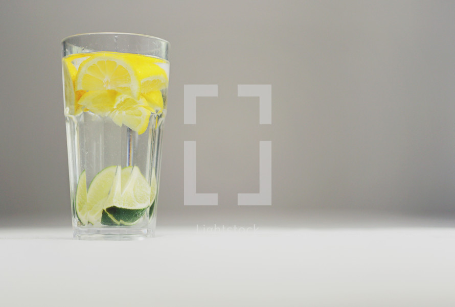 lemon and limes in a glass of water