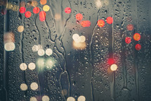 raindrops on the window and defocused street lights background