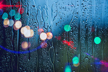 drops on the window and street lights background 