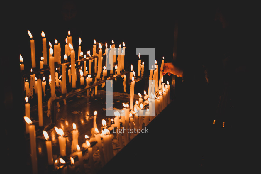 Candle flames in the church. Dark mood with burnt candles.