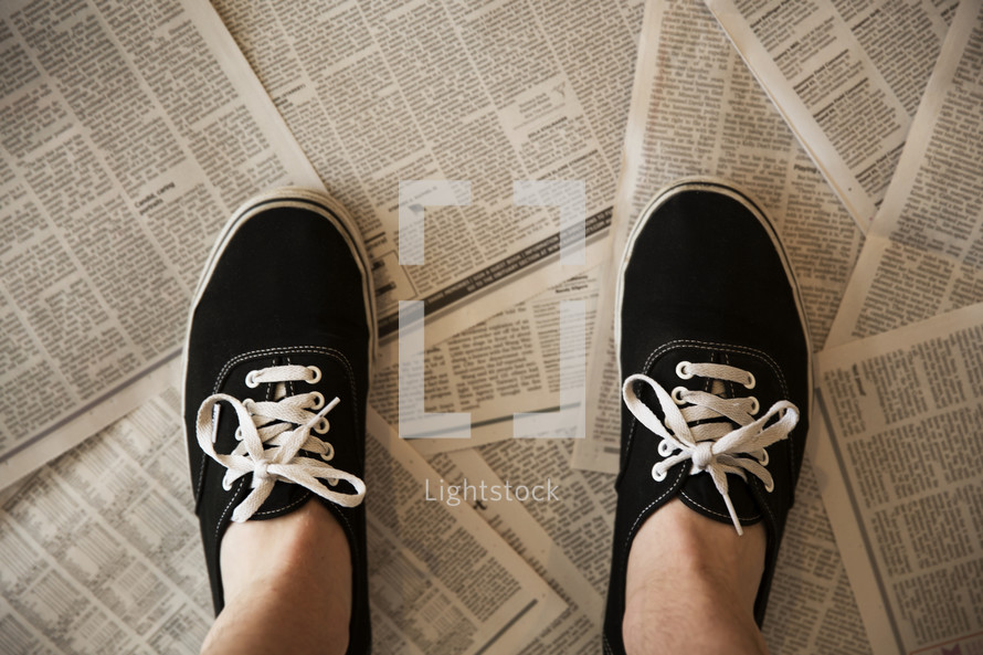 person standing on newspapers on the floor 
