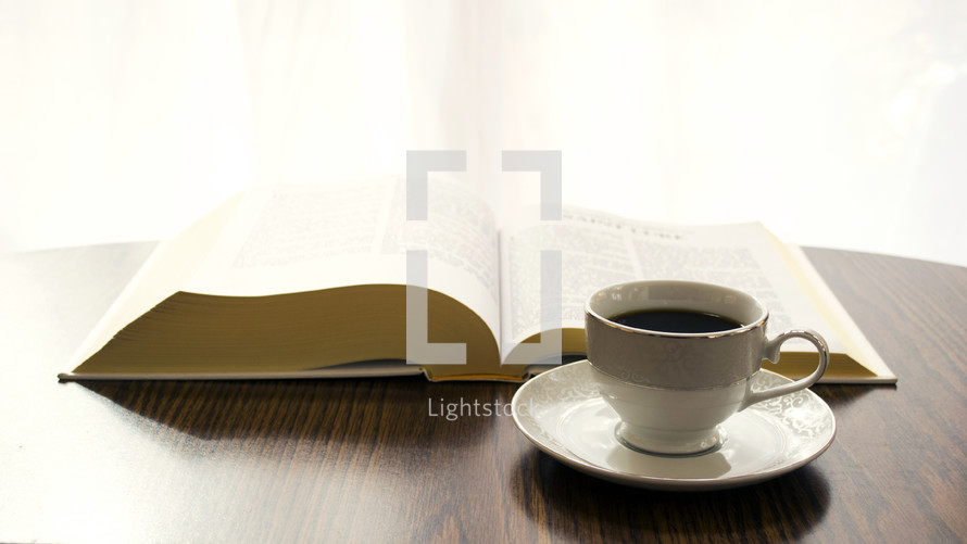 coffee cup and opened Bible on a table 
