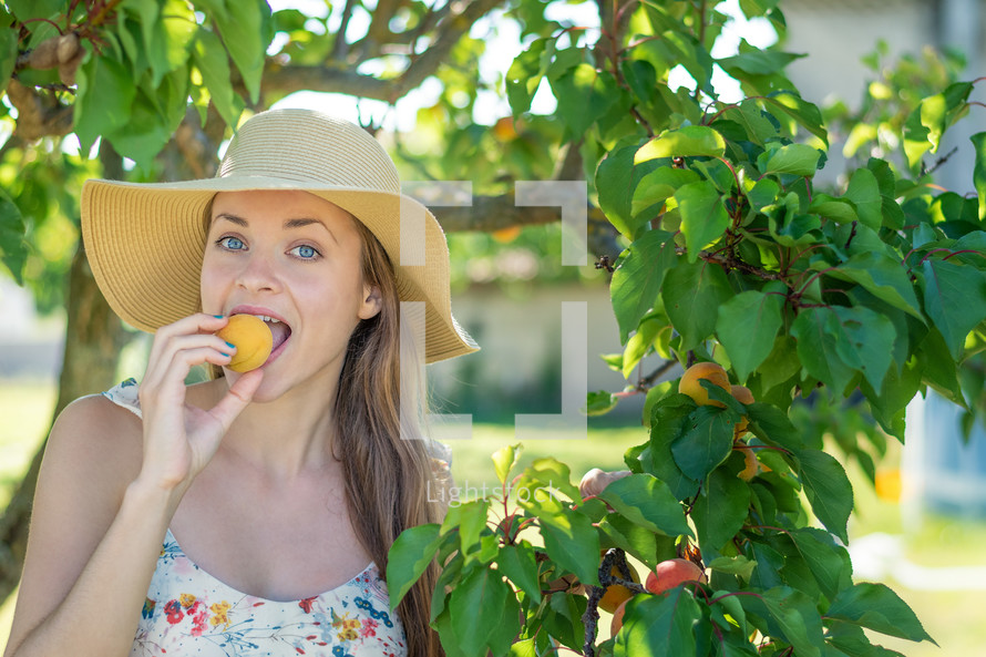 a woman eating an apricot 