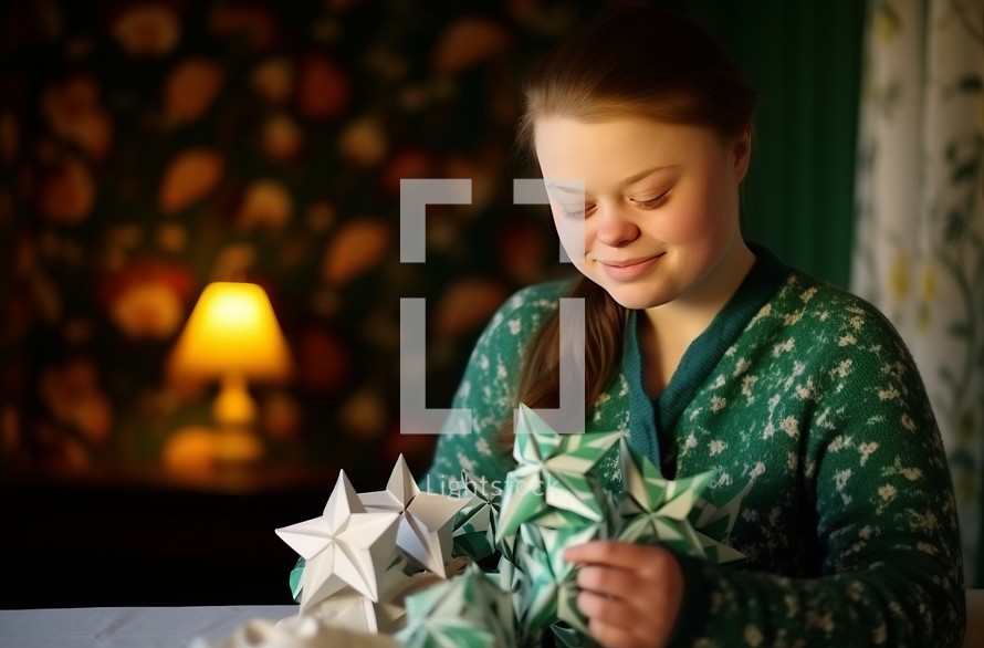 In a room with soothing green walls and soft, warm lighting, a 17-year-old girl with Down syndrome is joyfully engaged in making origami creations