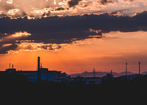 silhouette of smoke stacks at sunset 
