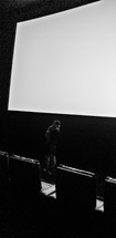 man standing in a dark auditorium 