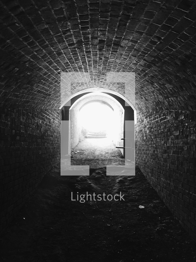 Bright light at the end of a stone tunnel.