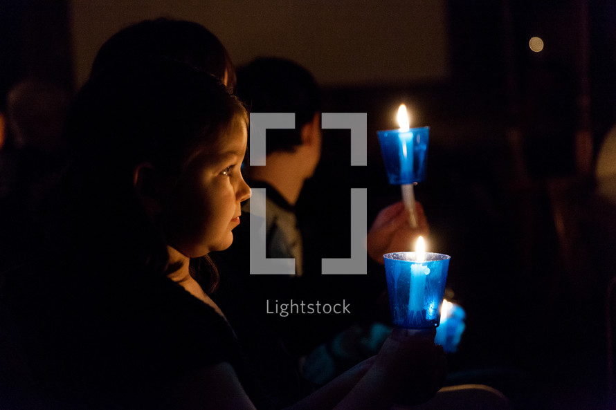 a child at a Christmas Eve candlelight service 