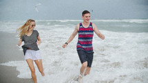 couple running through the ocean 