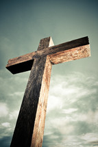 empty wooden cross under a dramatic cloudy sky
