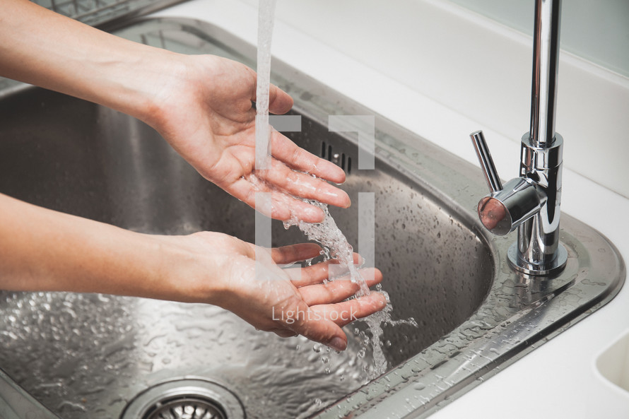 a woman washing her hands in a sink 