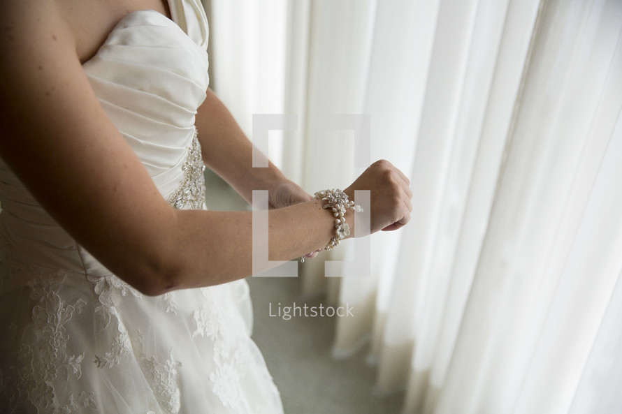 bride putting on a bracelet 