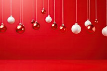 Christmas background with red and white baubles hanging on a red wall