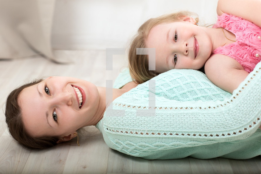 Smiling mother and daughter on the floor