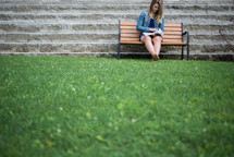 woman reading a Bible on a park bench 