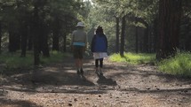 Two women walking together on a forest path
