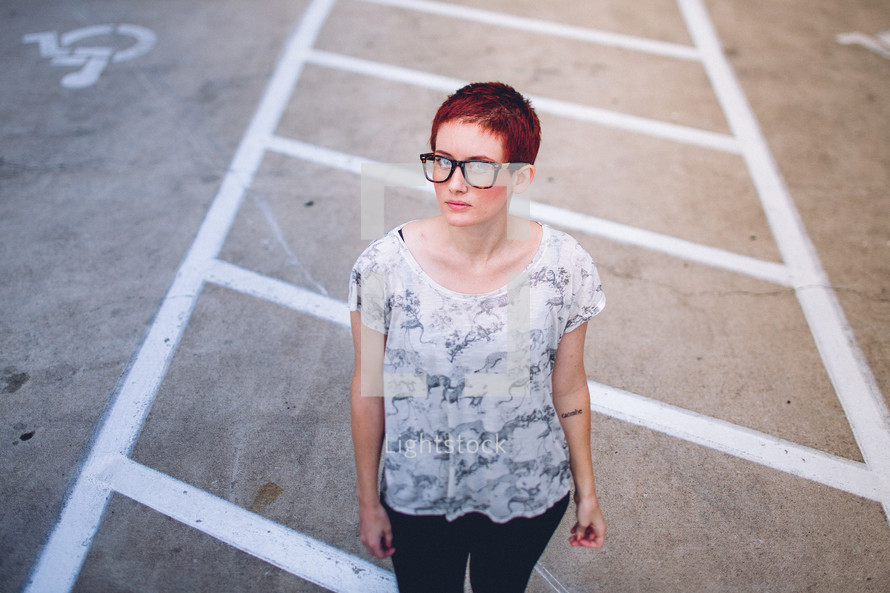 A woman standing in a parking lot. 