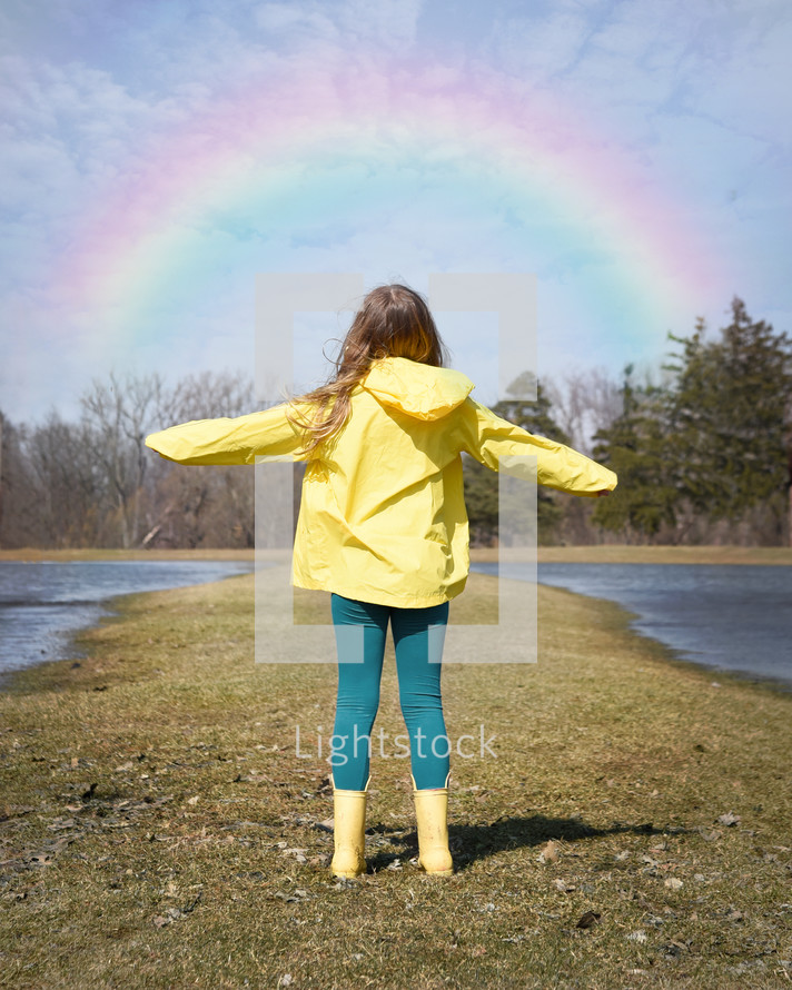 girl standing outdoors in rain boots 