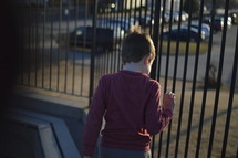 boy child looking through a railing 