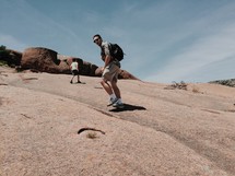 a man hiking up a rock slope 