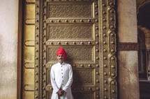 man in front of a large gold door 
