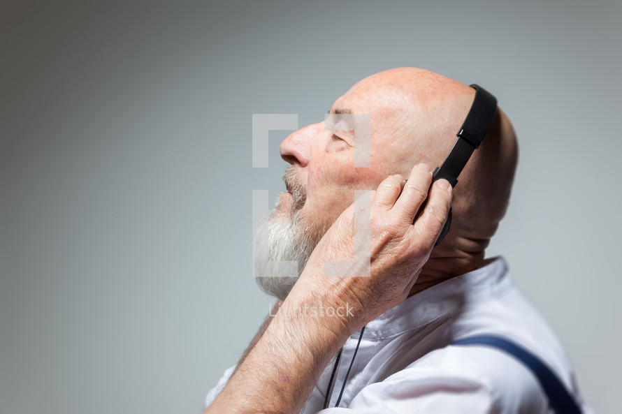 senior man listening to headphones 