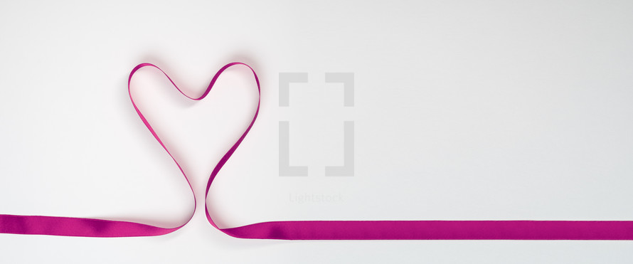 pink ribbon folded into the shape of a heart 
