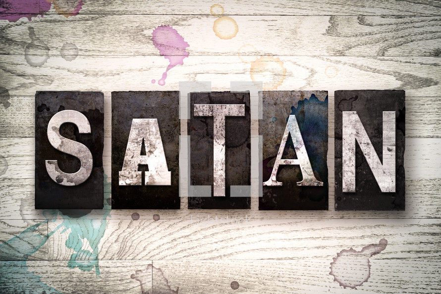 word satan on white washed wood
