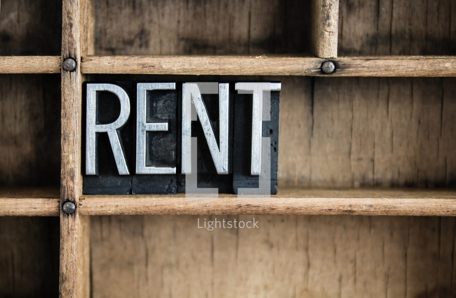 word rent in blocks on a bookshelf 