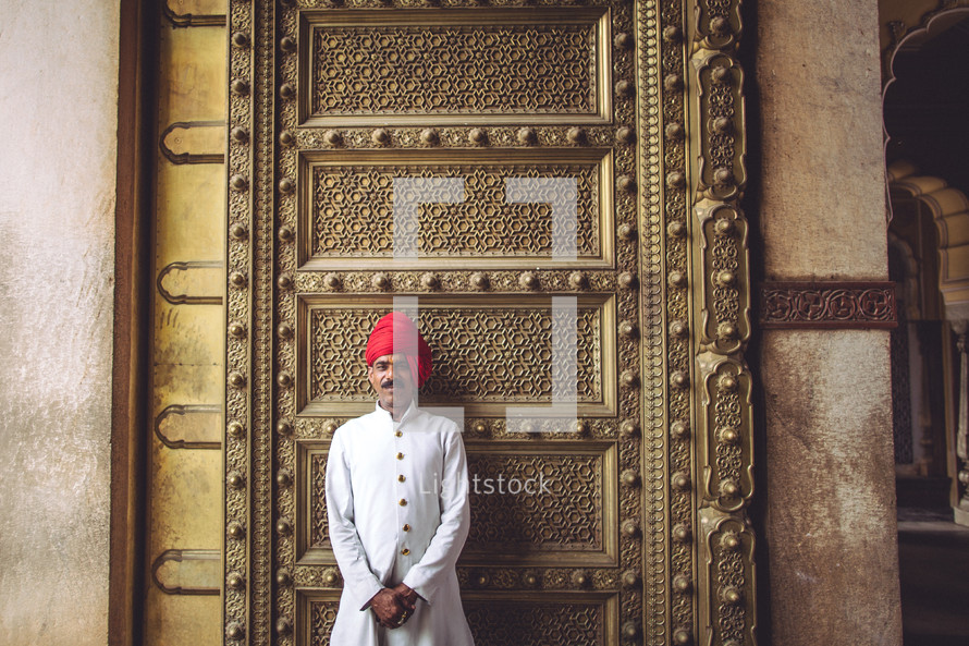 man in front of a large gold door 