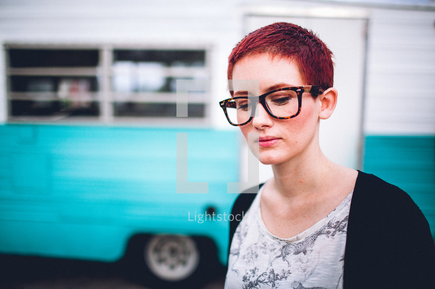 woman with short hair standing in front of an rv