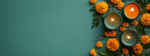 Teal candles and orange flowers on a green background. Concept of relaxation, spa, wellness, and aromatherapy.