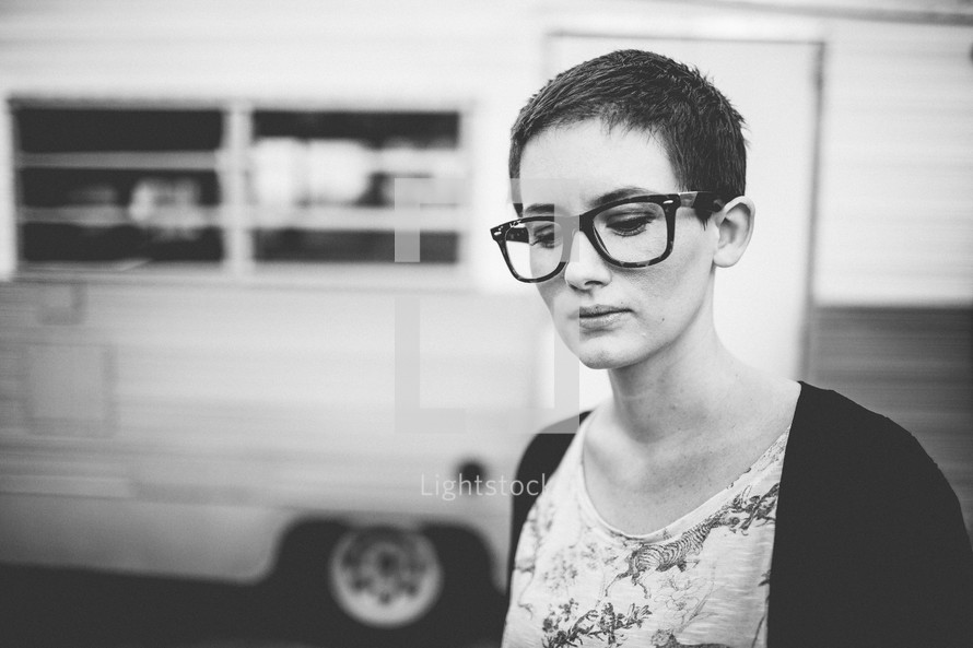 A woman with a pixie haircut wearing reading glasses. 