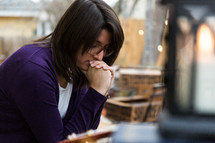 a brunette woman with head bowed in prayer 