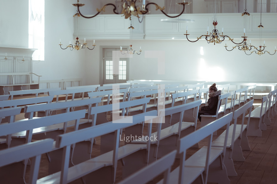 sitting in white church pews alone 