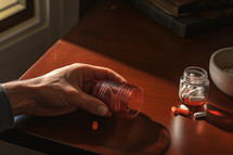 Hand and pills on the table